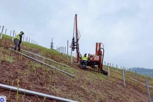 Personen und Gerätschaften bei der Arbeit am Hang